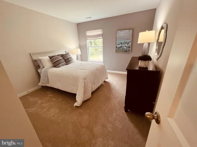 a spacious bedroom with a bed and wooden floor