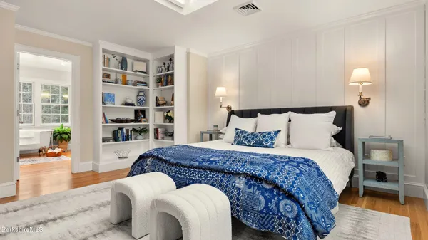 a bedroom with a large bed and a potted plant