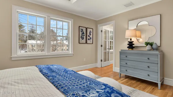 a bedroom with a bed and wooden floor