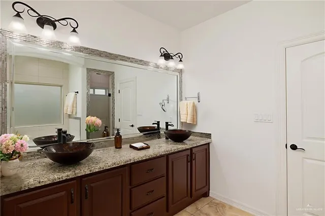 a bathroom with double sink and a mirror