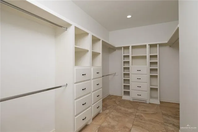 a view of walk in closet with empty racks