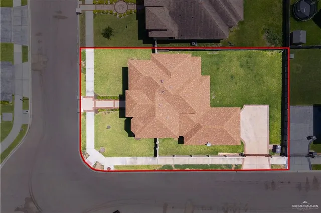 an aerial view of a house with a yard and pool