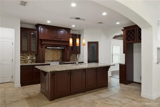 a kitchen with stainless steel appliances granite countertop a sink and a refrigerator