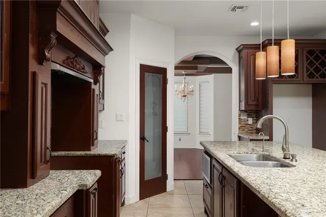 a kitchen with a granite countertop sink a stove and a refrigerator