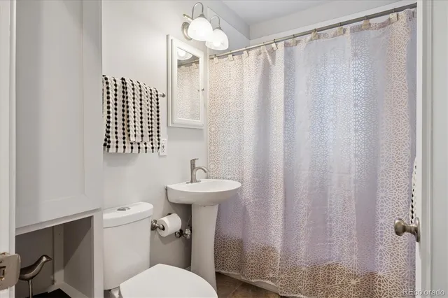 a bathroom with a sink a toilet and shower curtain
