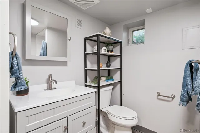 a bathroom with a sink a toilet and a mirror