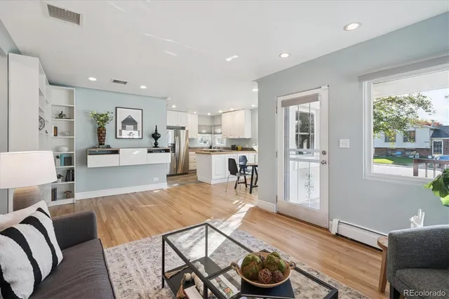 a living room with furniture and a wooden floor