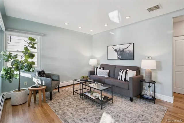 a living room with furniture and a wooden floor