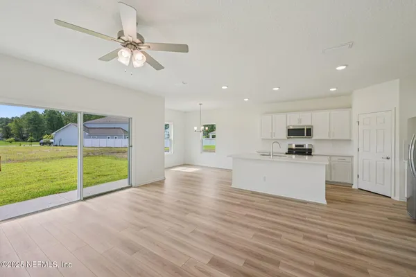 a view of kitchen with kitchen island wooden floor and window