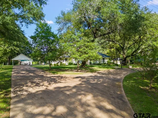 an aerial view of residential house with outdoor space and trees all around