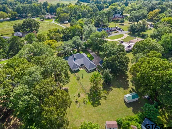 an aerial view of residential houses with outdoor space and trees