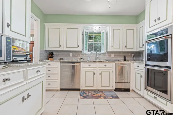 a kitchen with white cabinets appliances and a sink