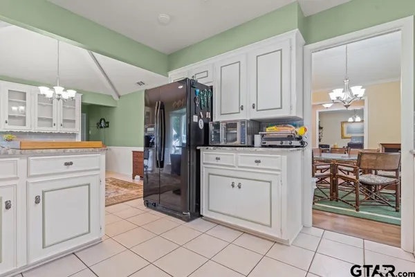 a kitchen with white cabinets and appliances