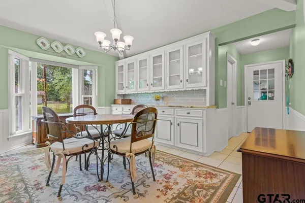 a view of a dining room with furniture and a chandelier