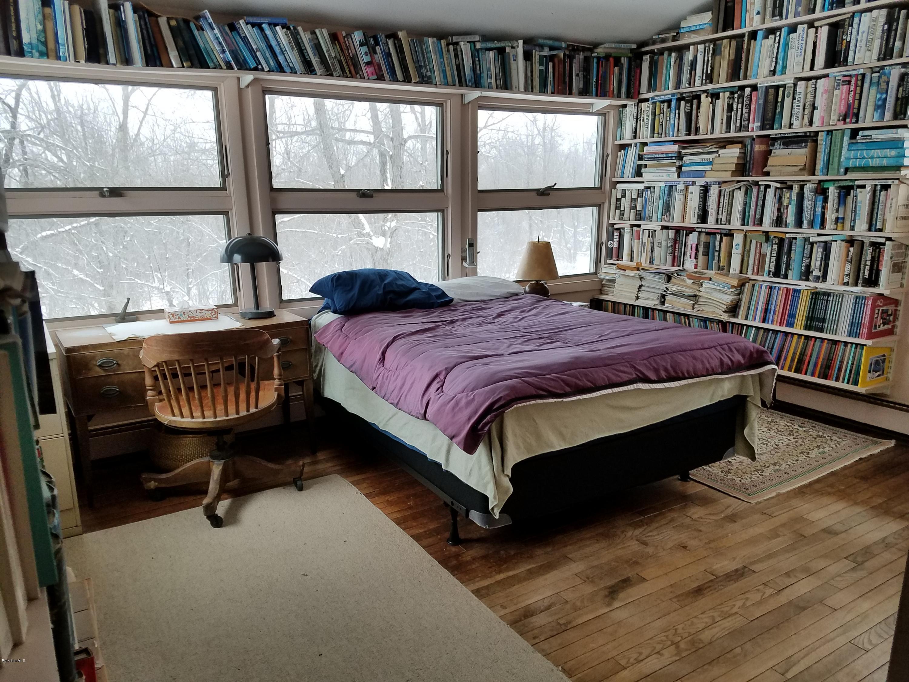 390 Bates Road Windsor, MA 01270 - Photo 40 of 73 a bed sitting in a bedroom next to a book shelf