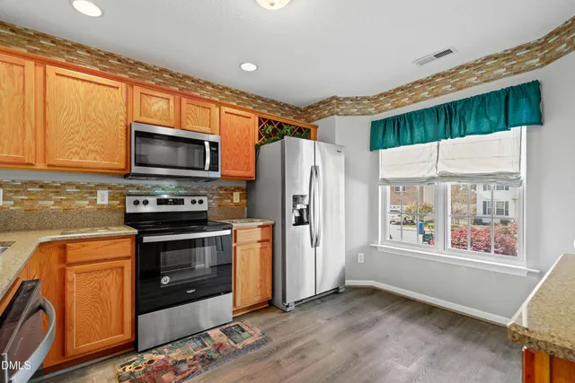 a kitchen with stainless steel appliances a stove a refrigerator and a microwave