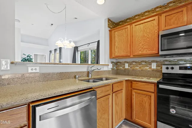 a kitchen with stainless steel appliances granite countertop a sink stove and microwave