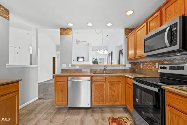 a kitchen with stainless steel appliances granite countertop a stove a sink and a microwave
