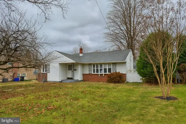 a front view of house with yard and trees around
