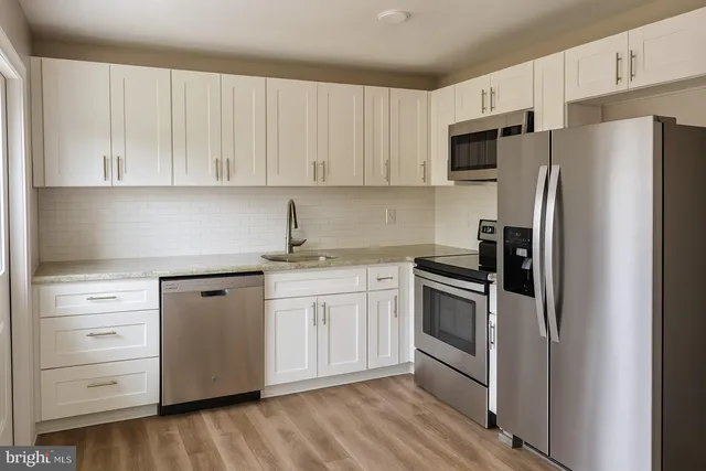 a kitchen with white cabinets and stainless steel appliances