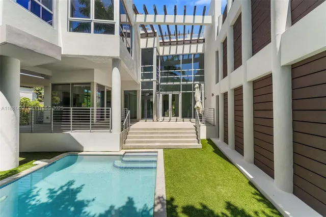 a view of a balcony with floor to ceiling window next to a yard