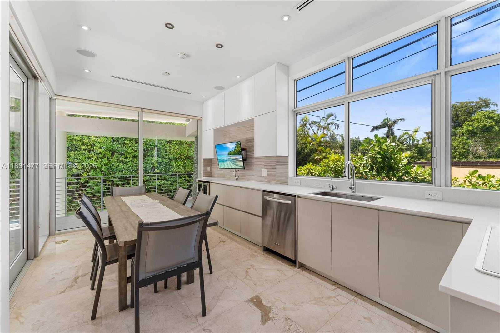 544 Fernwood Road, Unit 544 Key Biscayne, FL 33149 - Photo 21 of 35 a kitchen with a window a sink and chairs