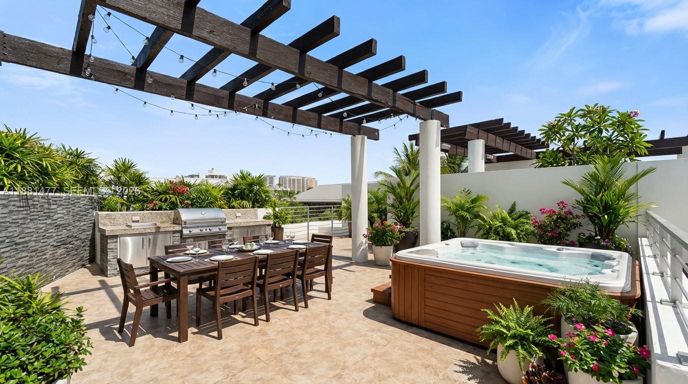 544 Fernwood Road, Unit 544 Key Biscayne, FL 33149 - Photo 4 of 35 a view of a patio with table and chairs potted plants with wooden floor