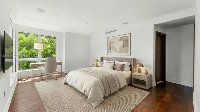 a bedroom with a bed and a large window