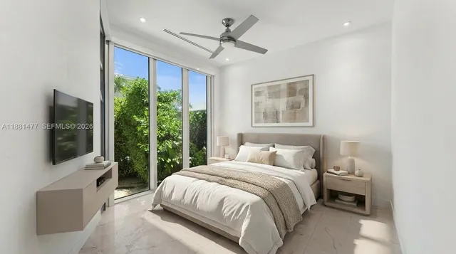 a bedroom with a large bed and a flat tv screen on dresser