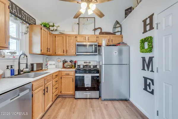 a kitchen with stainless steel appliances granite countertop a refrigerator a stove and a sink