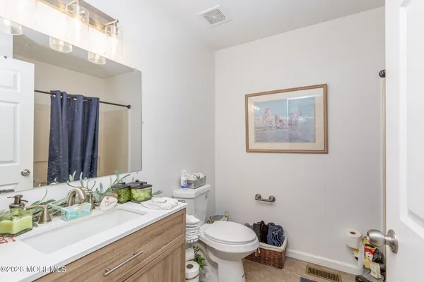 a bathroom with a granite countertop sink mirror vanity and toilet