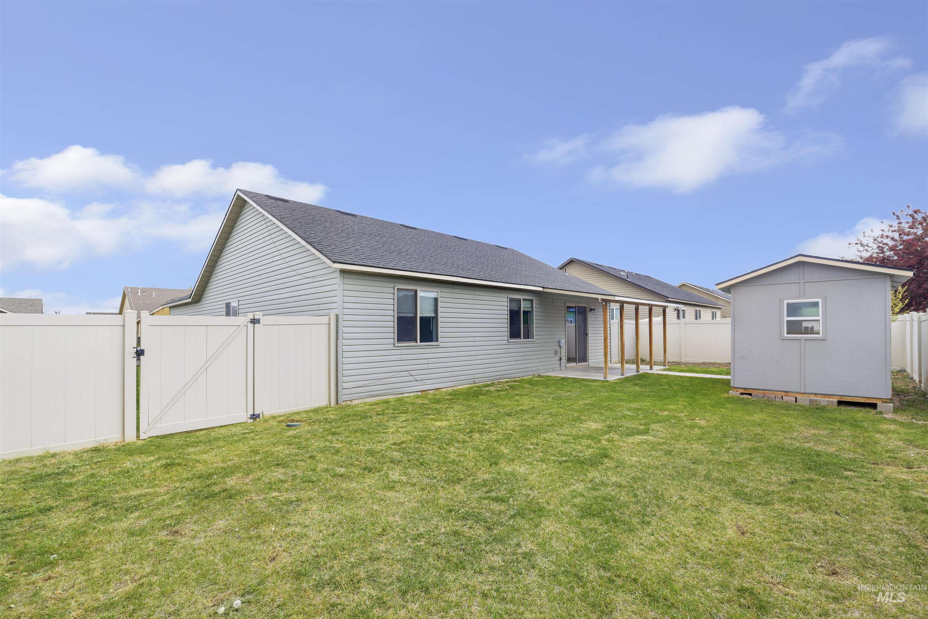 356 Watchmaker Street Twin Falls, ID 83301 - Photo 22 of 22 Back of house featuring a gate, a patio area, a fenced backyard, roof with shingles, and a shed