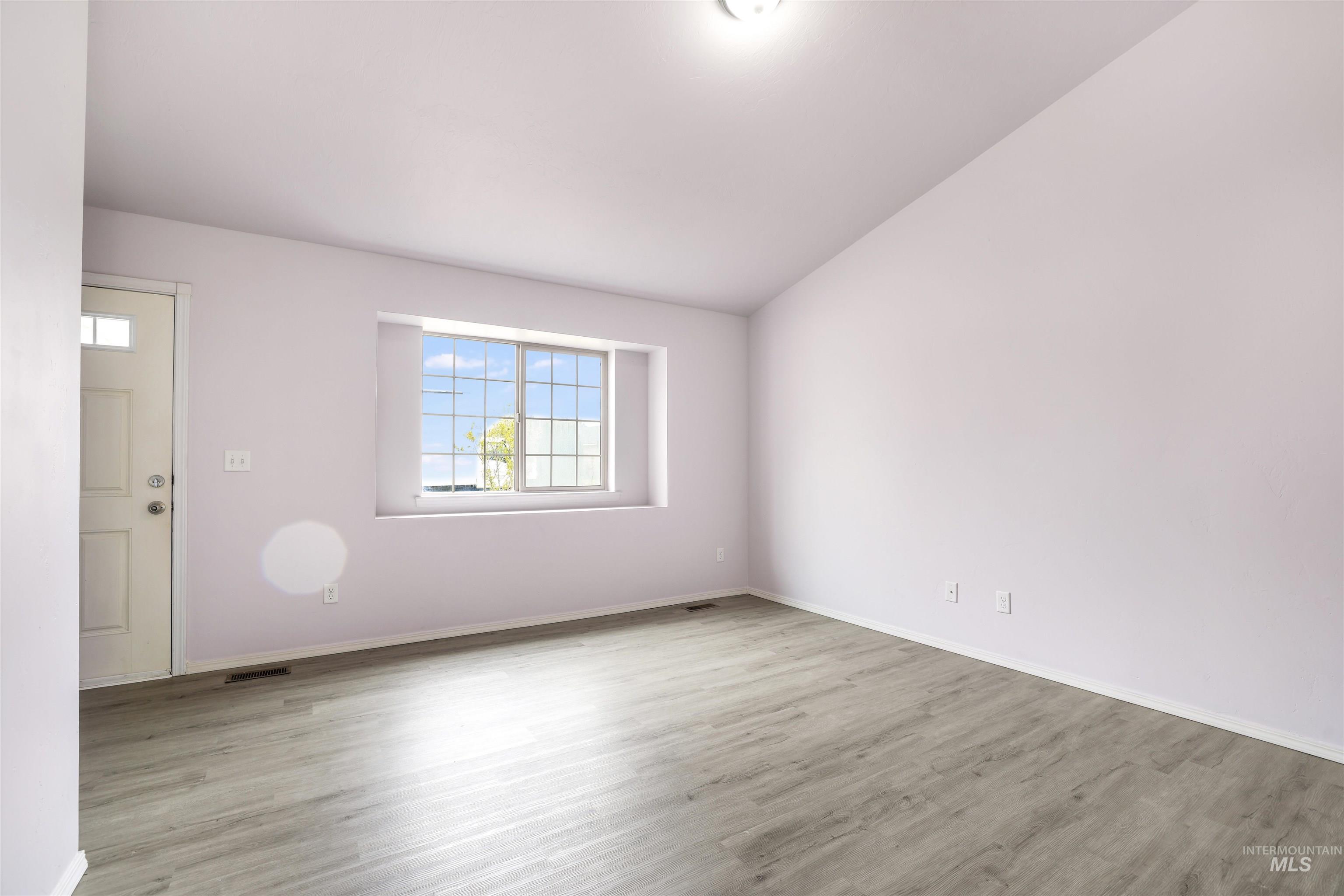 356 Watchmaker Street Twin Falls, ID 83301 - Photo 5 of 22 Empty room featuring lofted ceiling and light wood-type flooring
