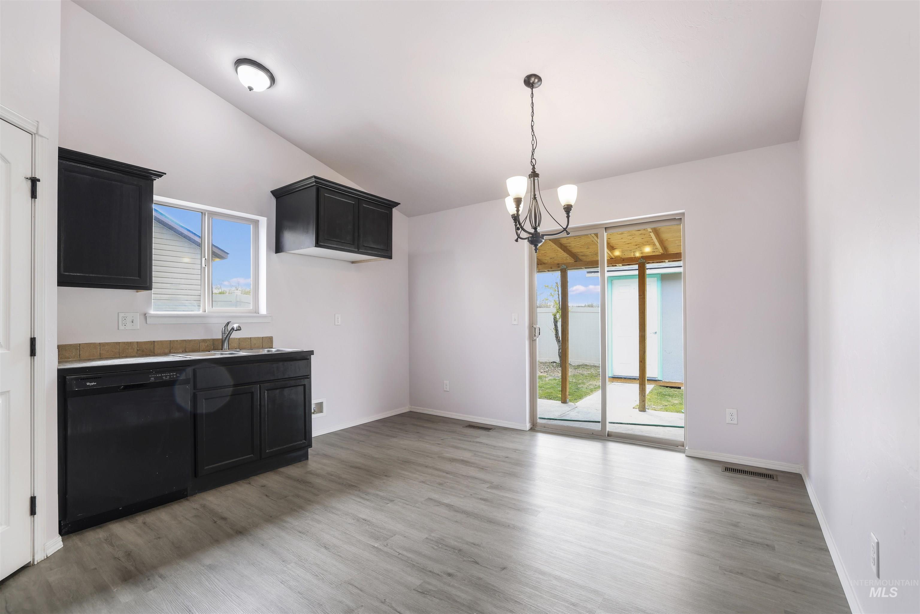 356 Watchmaker Street Twin Falls, ID 83301 - Photo 7 of 22 Unfurnished dining area with suspended lighting, lofted ceiling, and light wood-type flooring