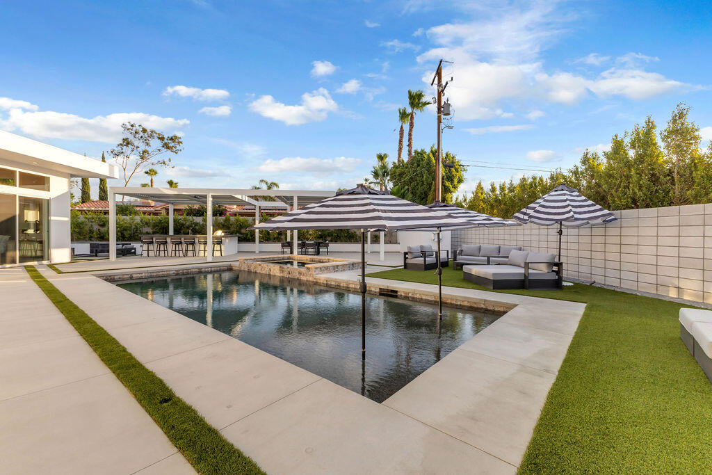 2100 East Sahara Road Palm Springs, CA 92262 - Photo 32 of 117 a view of a swimming pool with a lounge chairs