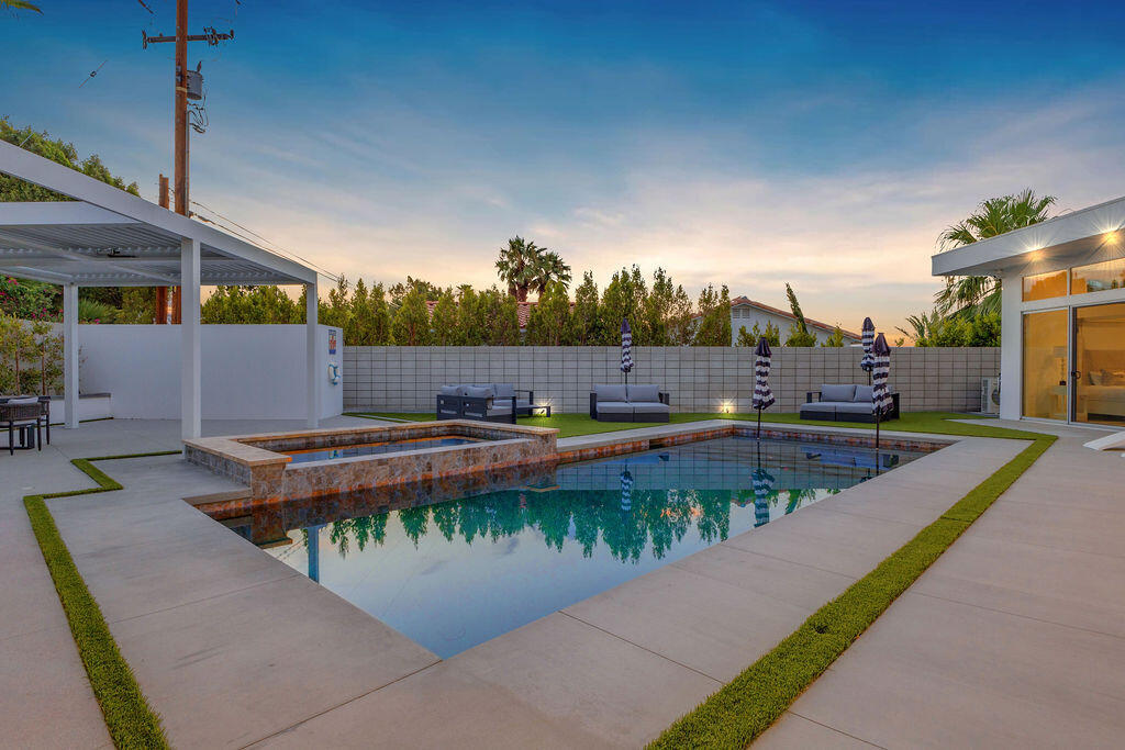 2100 East Sahara Road Palm Springs, CA 92262 - Photo 85 of 117 a view of a swimming pool with a patio and a garden