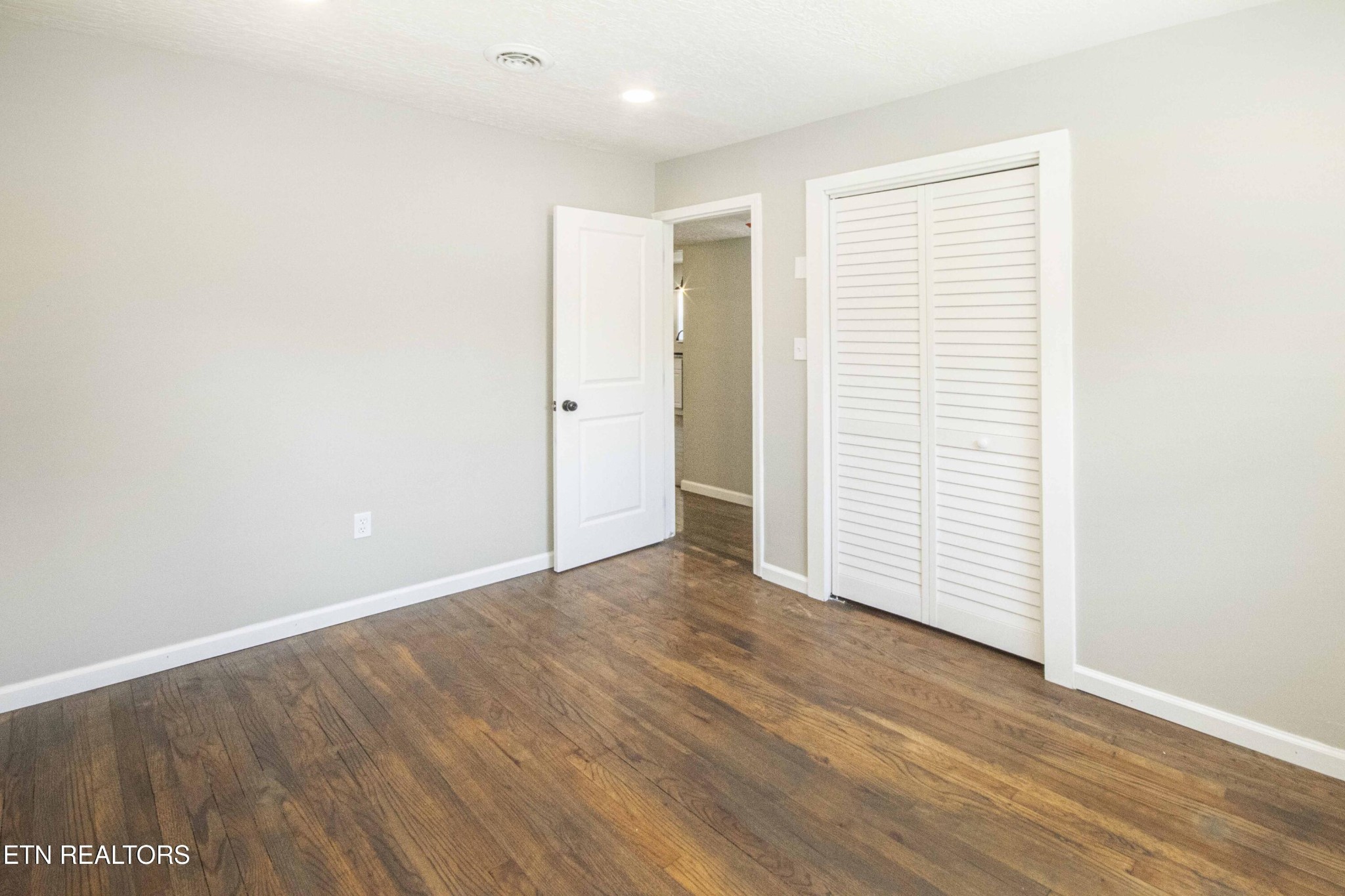 110 Delmar Circle Oak Ridge, TN 37830 - Photo 19 of 38 an empty room with wooden floor and white walls