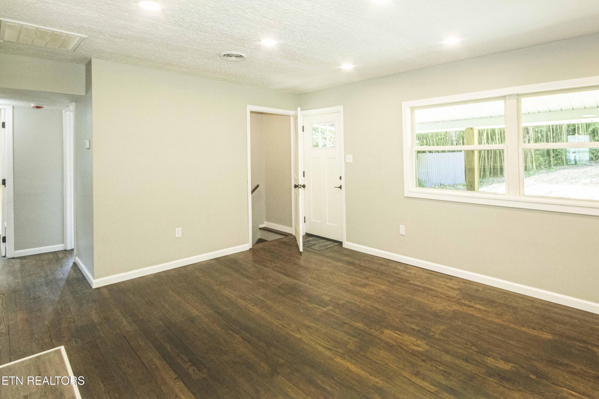 110 Delmar Circle Oak Ridge, TN 37830 - Photo 9 of 38 an empty room with wooden floor and windows
