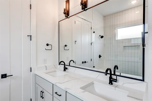 a bathroom with a granite countertop sink a mirror and shower