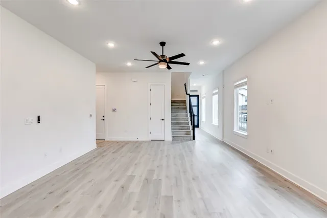 an empty room with a window and a ceiling fan