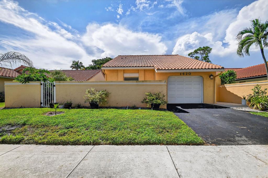 1620 Northwest 22nd Avenue Delray Beach, FL 33445 - Photo 2 of 63 a front view of a house with a garden