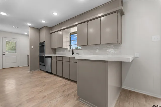 a kitchen with a sink stainless steel appliances and cabinets