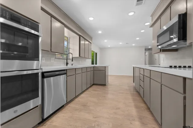 a kitchen with stainless steel appliances a sink stove and cabinets