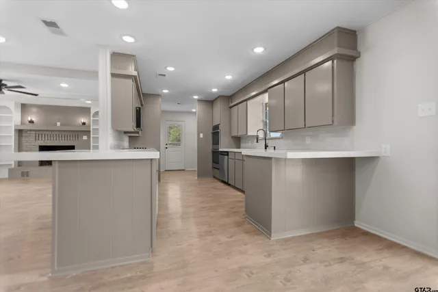 a large kitchen with stainless steel appliances kitchen island a large counter top a stove and a sink