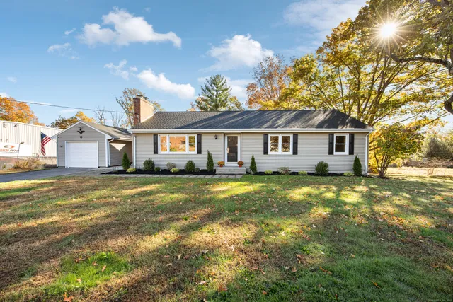 a view of a house with a big yard and large trees