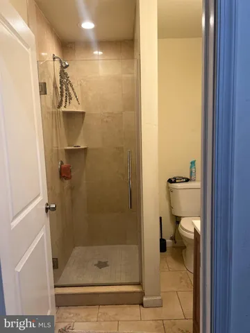 a bathroom with a granite countertop shower a toilet and a sink