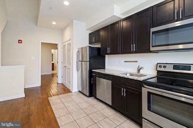a kitchen with stainless steel appliances granite countertop a stove microwave and refrigerator