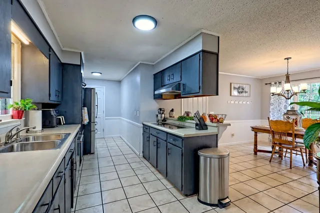 a kitchen with stainless steel appliances a sink stove and cabinets