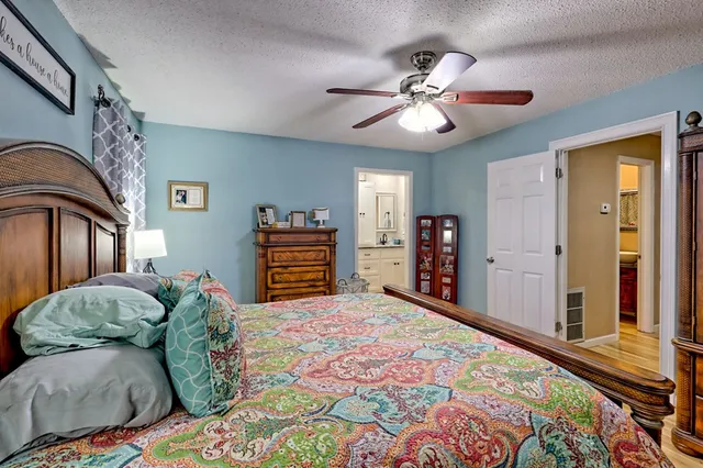 a bathroom with a granite countertop double vanity sink mirror and shower