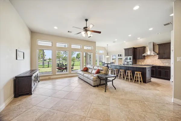 a living room with furniture and a large window with kitchen view